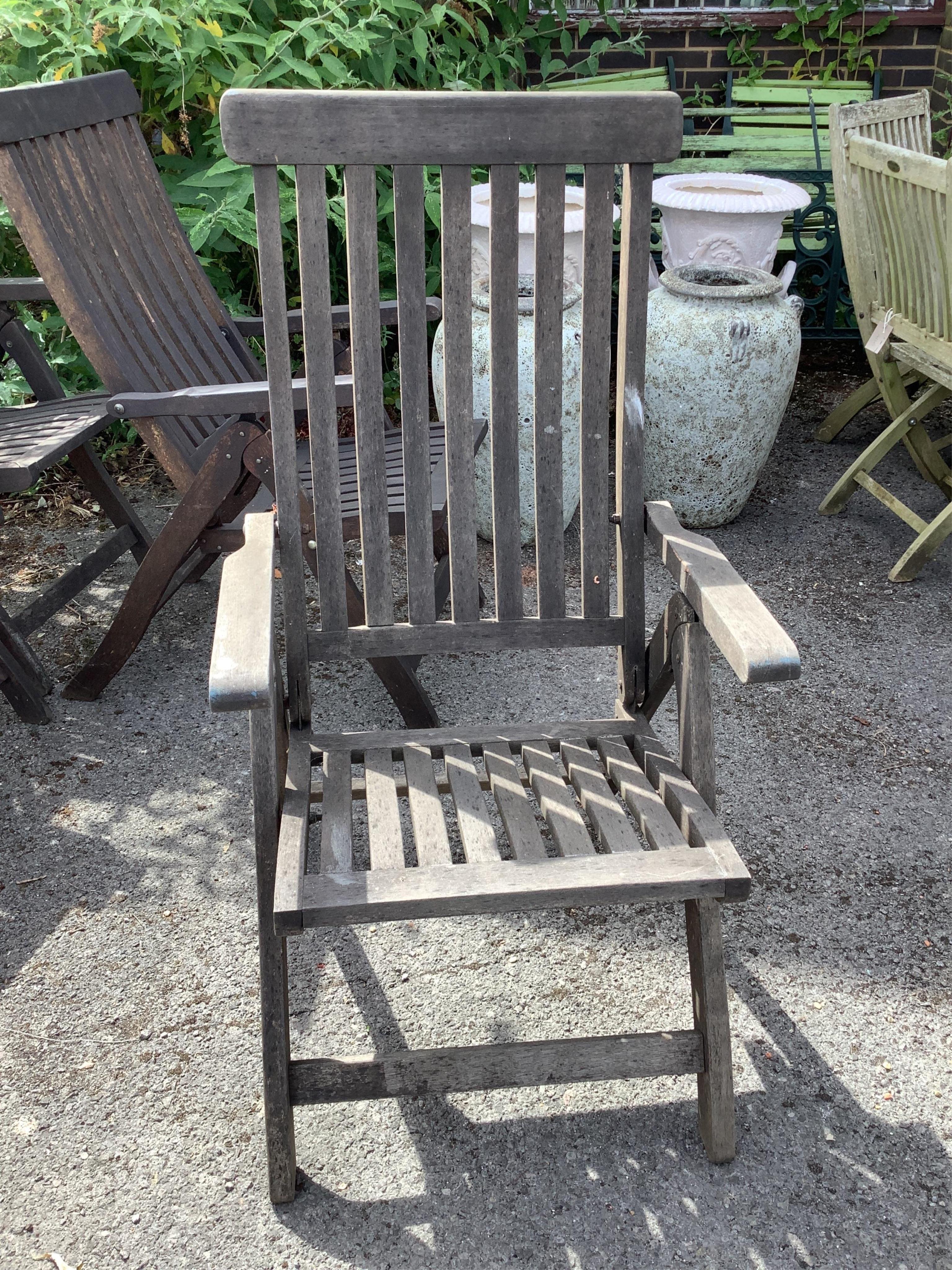 A set of four stained teak folding garden armchairs. Condition - fair